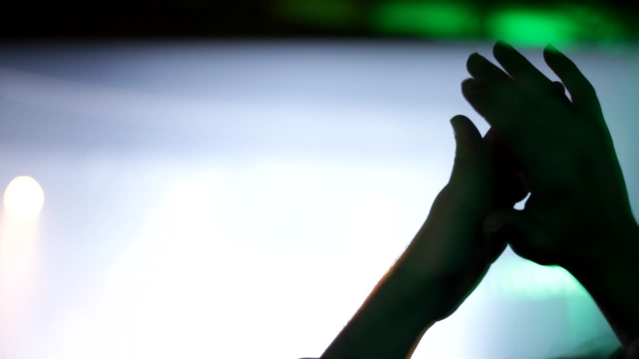 Close up shot of cheering party people during night show on stage. Clapping hands of public.