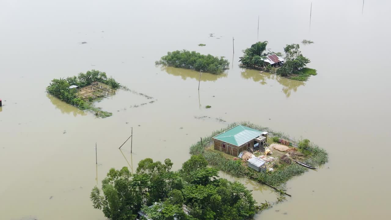 Aerial over flooded affected area in rural Bangladesh, homes with flood barrier installed