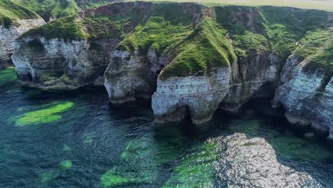 beautiful chalk coastal cliffs at low tide, with visible cracks showing in the cliff faces