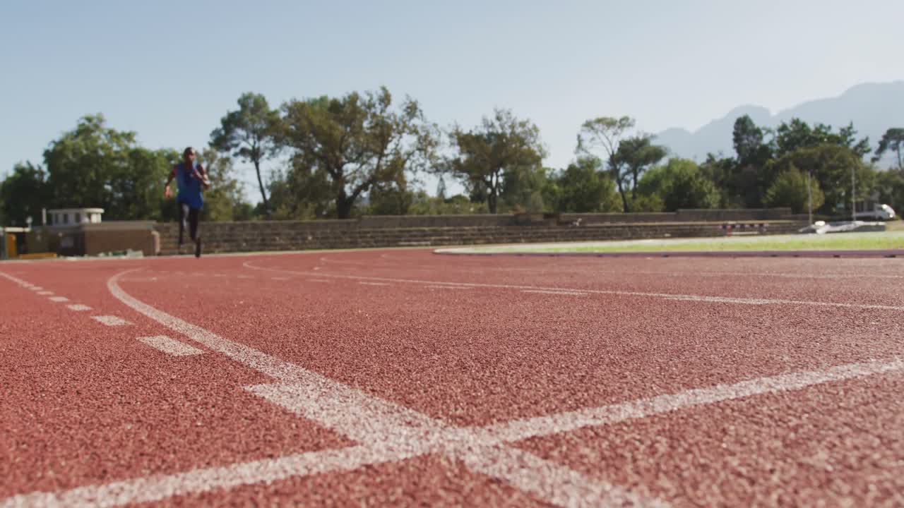 hombre de raza mixta discapacitado con piernas protésicas corriendo en la pista de carreras