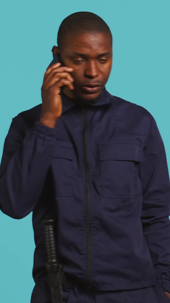 African American Man in Uniform Talking on Smartphone