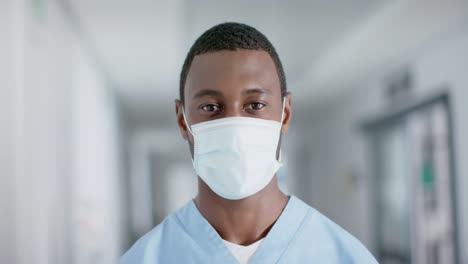 portrait of african american male doctor wearing face mask, slow motion