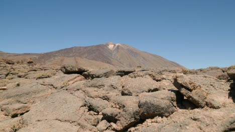 Pico-del-Teide-revealed-behind-sharp-volcanic-rocks-in-Los-Roques-de-Garcia,-Teide-National-Park-in-Tenerife,-Canary-Islands-in-spring