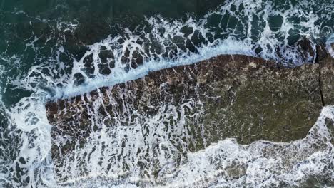 waves crashing on the rocky coastline of the tropical island