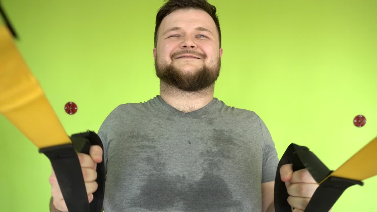 gordo hombre caucásico barbudo trabaja en un moderno gimnasio en bucles, desarrollando resistencia y músculo, exceso de peso