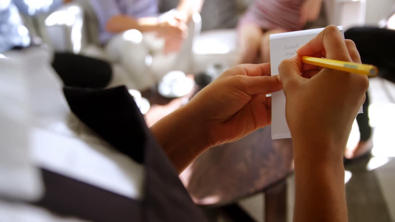 camarera escribiendo en un bloc de notas en un restaurante