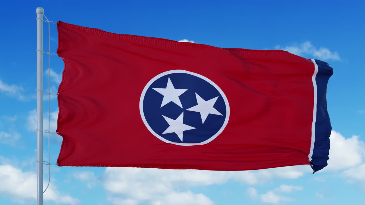 la bandera de tennessee en un asta de bandera ondeando en el viento, fondo de cielo azul. 4k