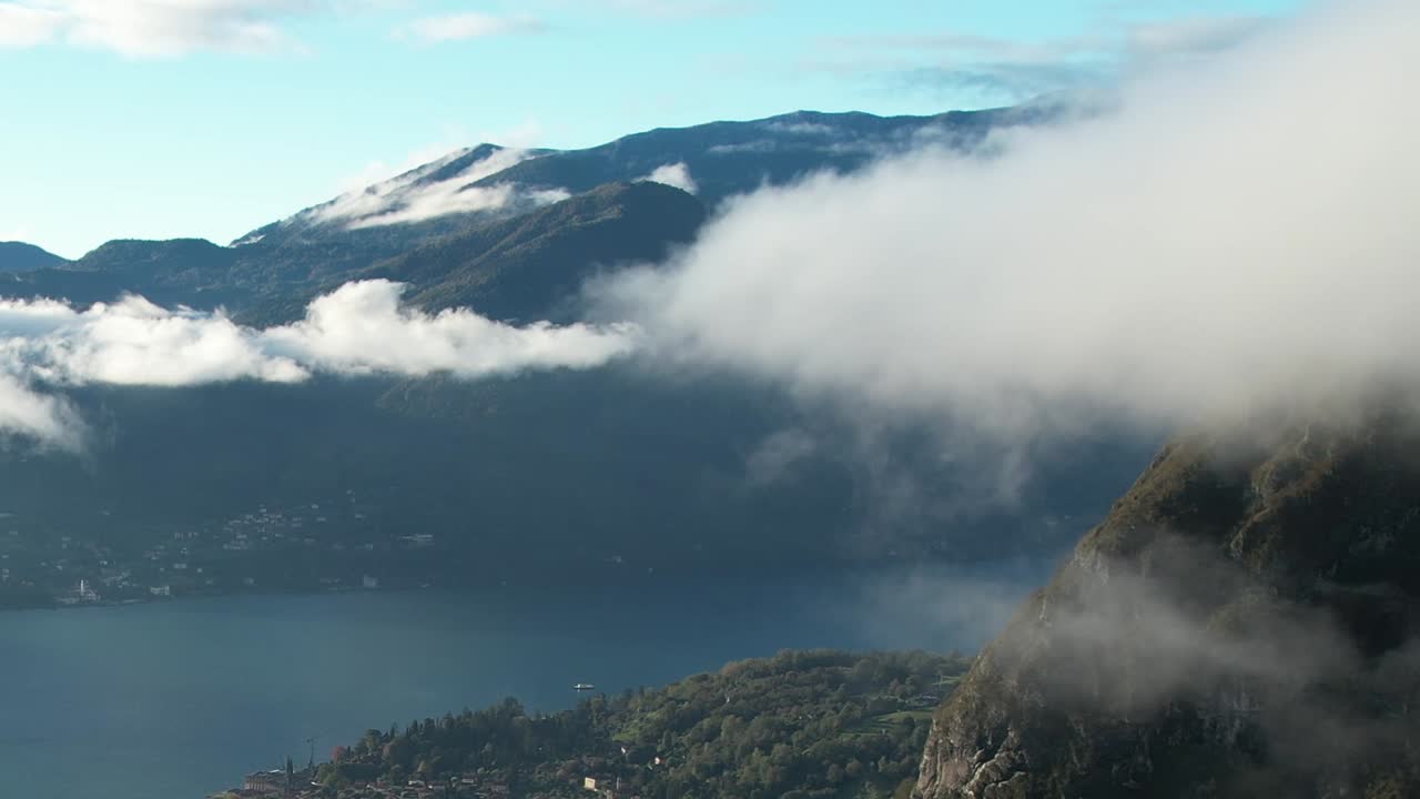 Expansive aerial view of the Italian Alps with serene lake below