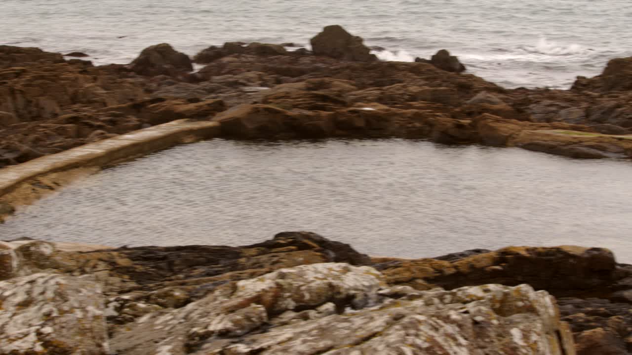 Lavvinkelbillede af Mousehole Rock Pool tidevandsbassin i Cornwall.