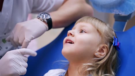 Little child smiles in stomatology chair. Kid patient is given a toy. Healthy teeth concept - close up video.