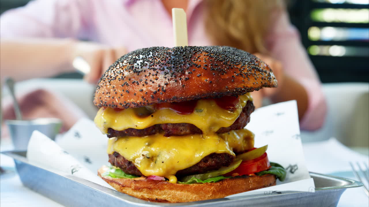 Close up of a big hamburger on a table at a restaurant