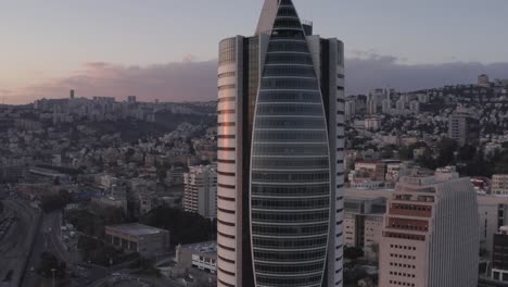 modern skyscraper in city skyline at sunrise/sunset