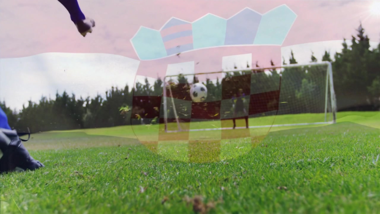 Striker in sports jogging and initiating crest overlay while scoring penalty past diving keeper