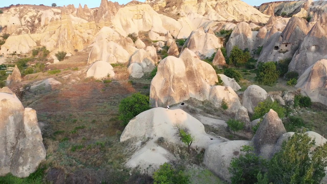 Vista panoramica aerea con drone delle iconiche formazioni rocciose a camino delle fate e delle ripide creste montuose di tufo erose nella Valle dell'Amore, Cappadocia, Nevsehir, Turchia, durante l'ora d'oro.