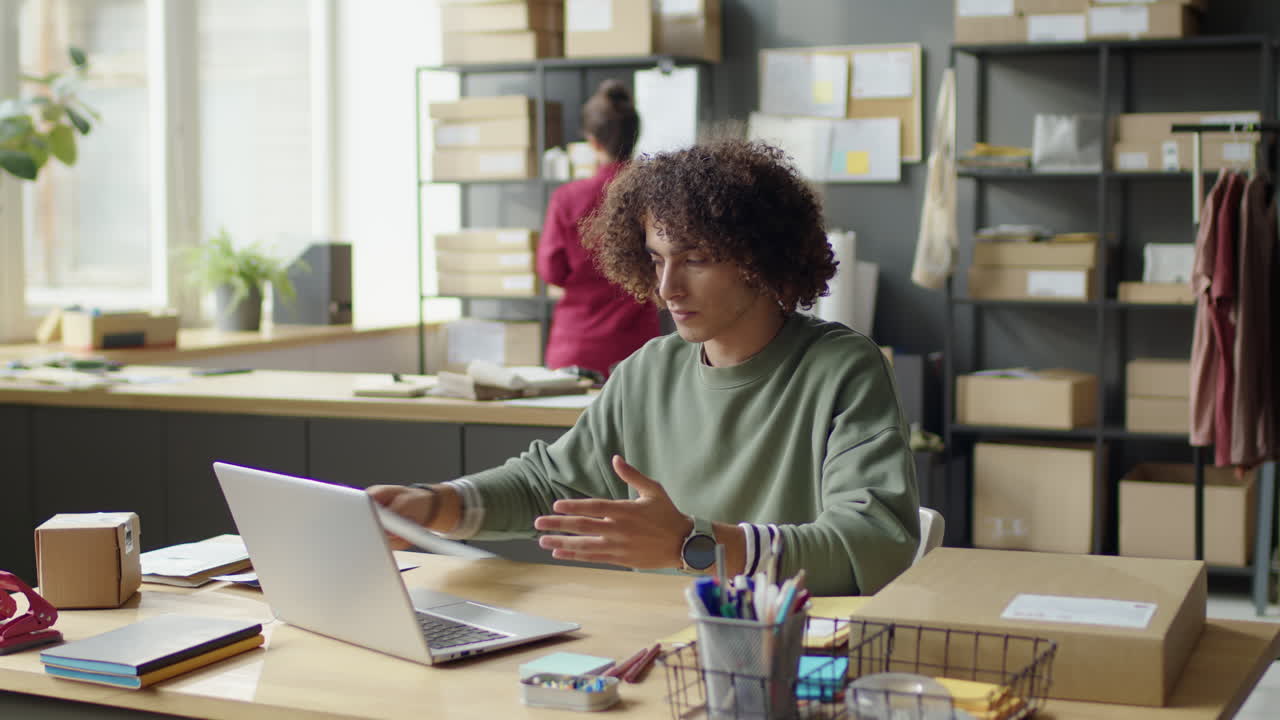 People working in an office with boxes and a laptop