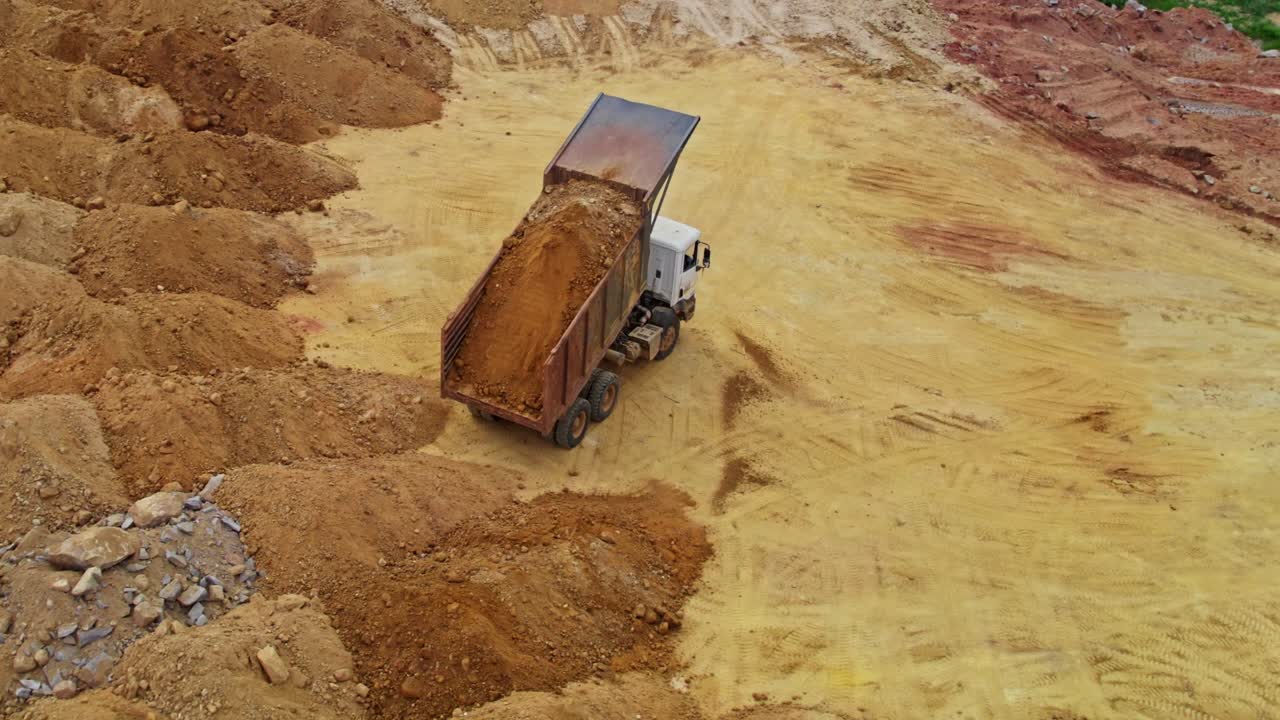 sand dump in construction area with truck unloading sand at telangana, india. day time, semi orbit, drone shot. 4k
