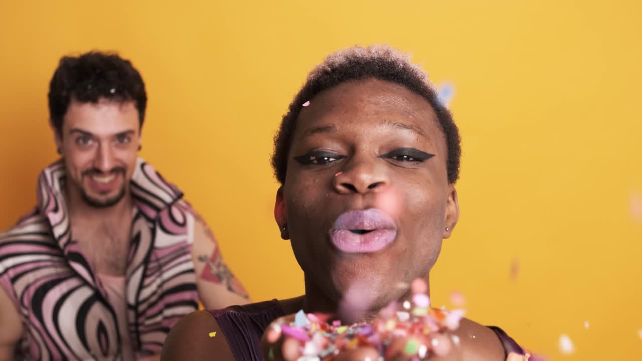 Transgender men dancing and blowing confetti