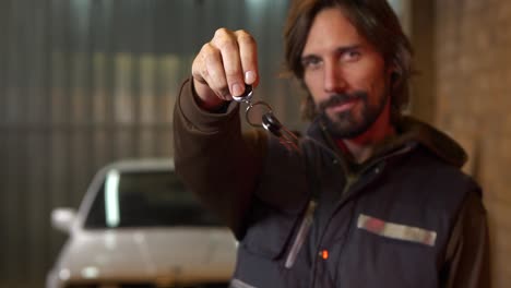 mechanic man holds out car keys and jingles them in circles, close up