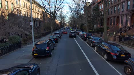 aerial down a block of brownstone apartments in new york city or brooklyn