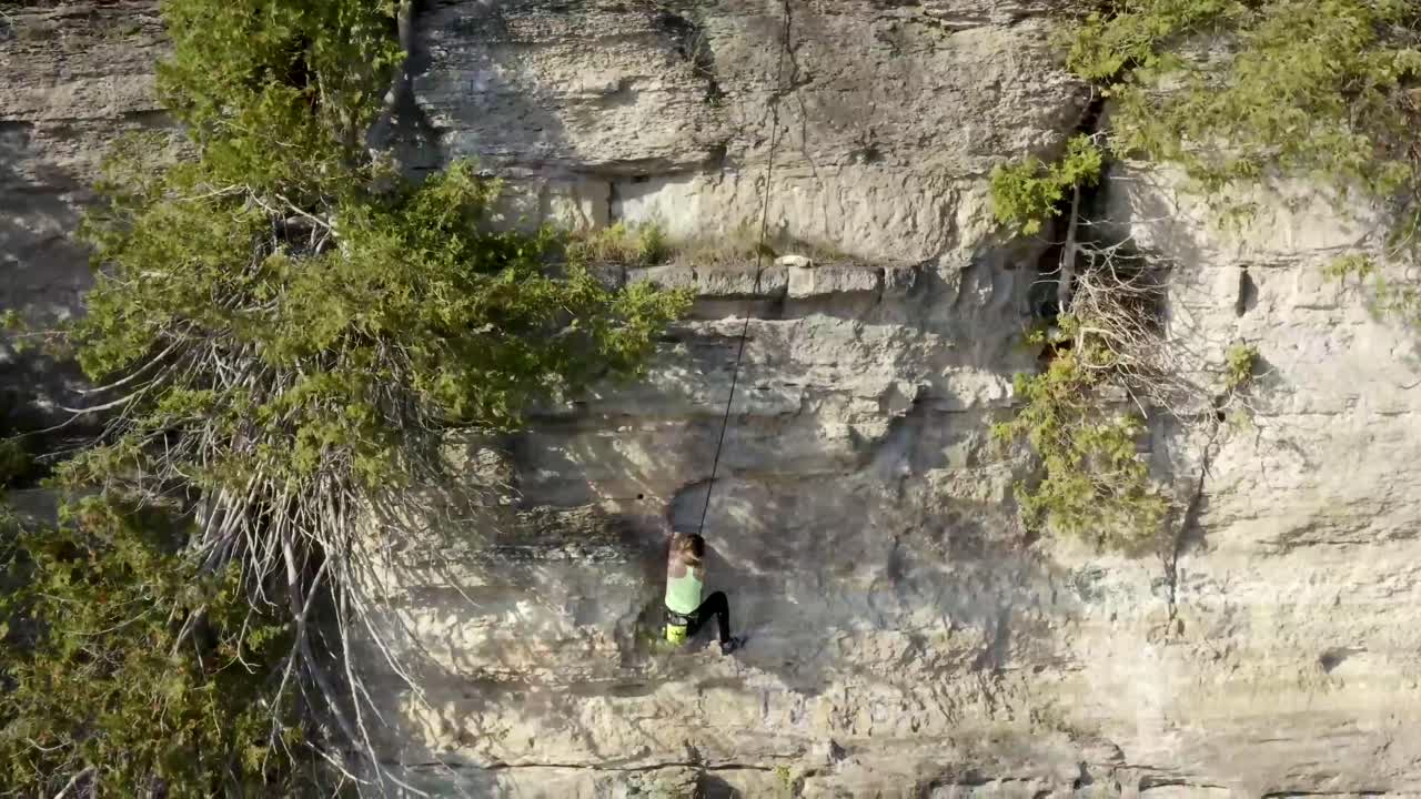 Girl Rock Climber Scaling an Outdoor Rock Wall Cliff - Adventure Sports - Extreme Sports - Action Sports - Rock Climbing
