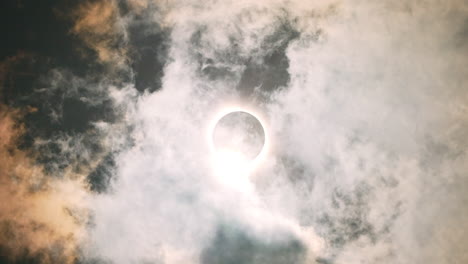 solar eclipse april 2024 with clouds passing over the sun and moon in the sky, epic cinematic shot