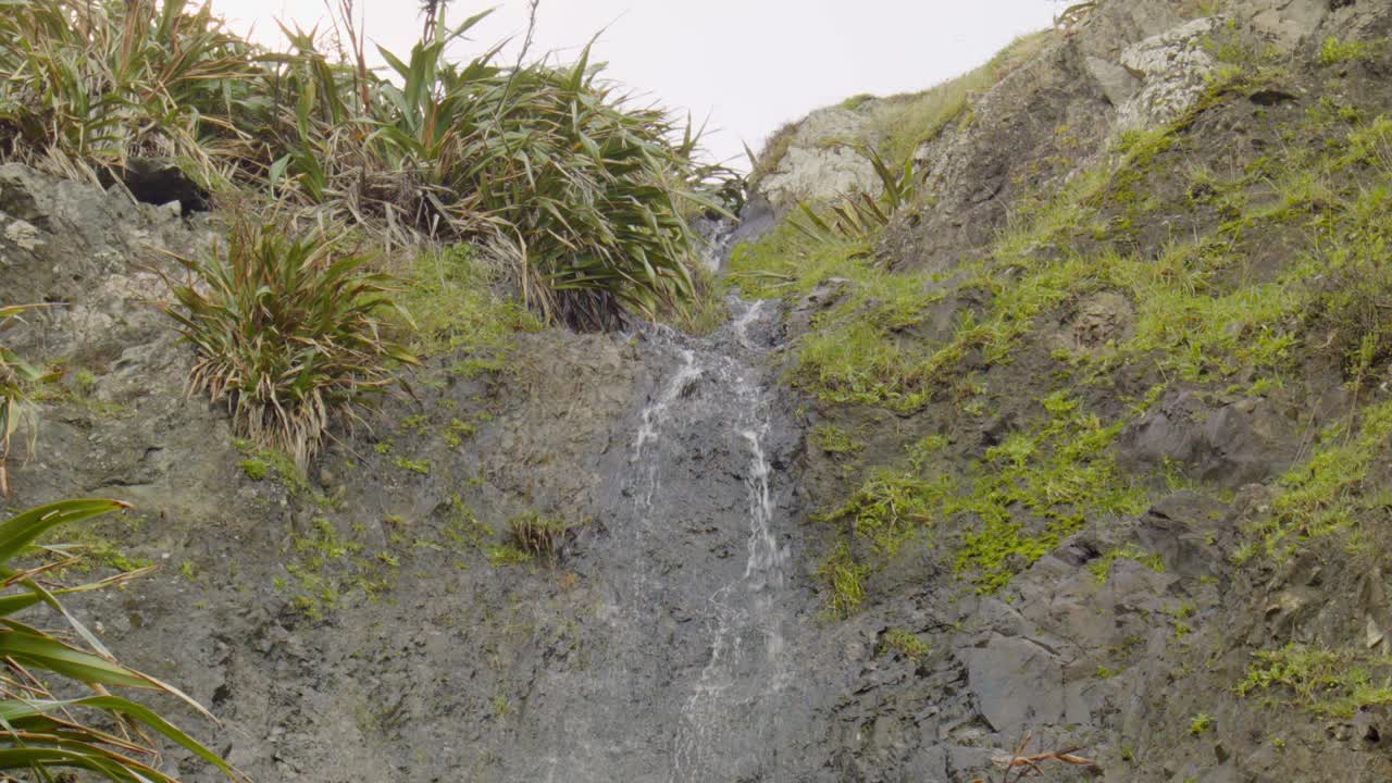 zoomado en la toma de la parte superior de una pequeña cascada en nueva zelanda