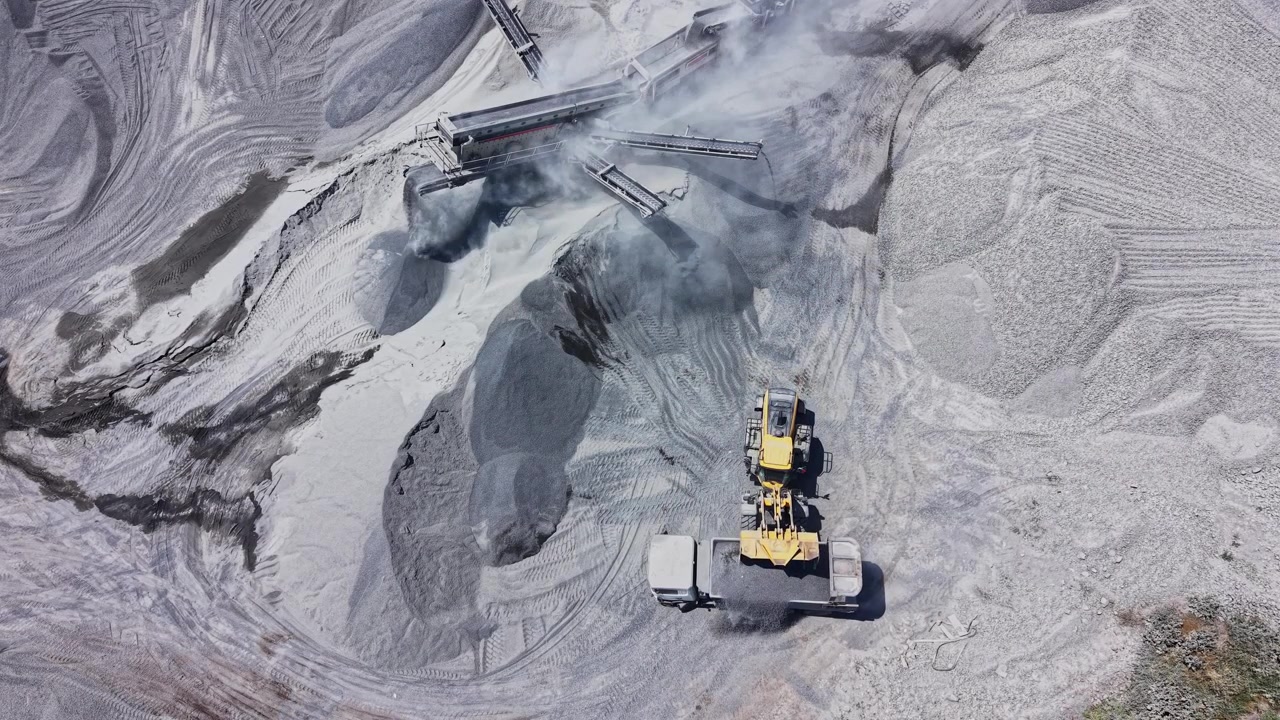 Heavy machinery working in gravel pit during day