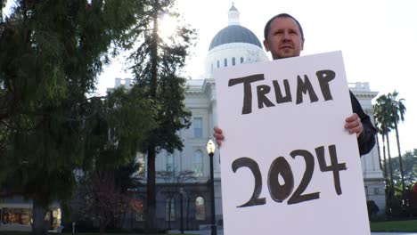 male political protester with trump 2024 sign