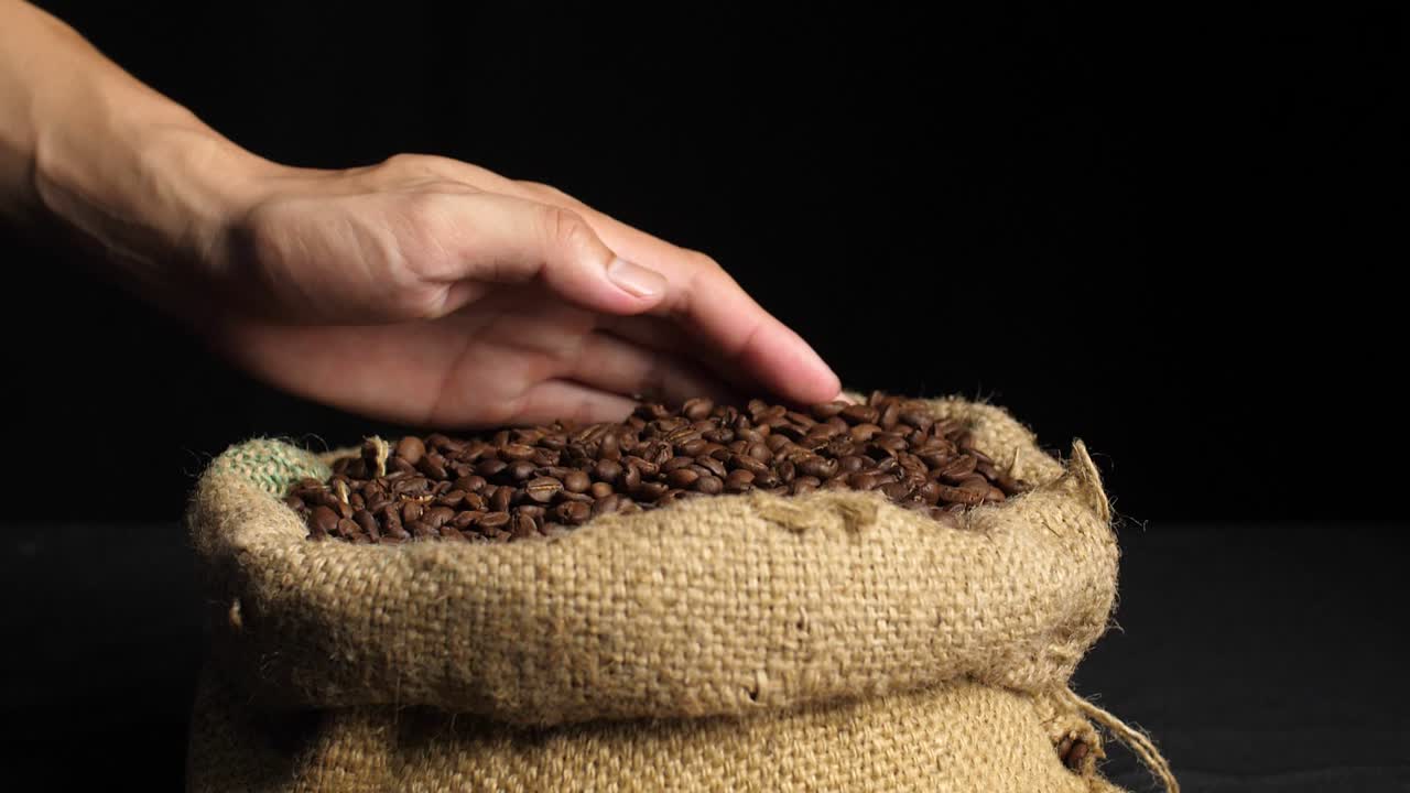 Coffee Beans In Hands On Dark Background, Slow Motion