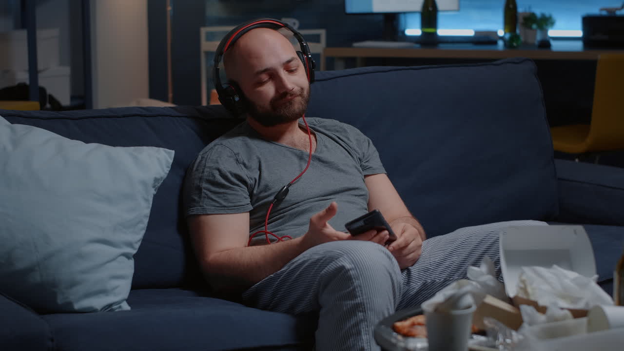 Helpless man with chronic depression putting on headset listening sad music