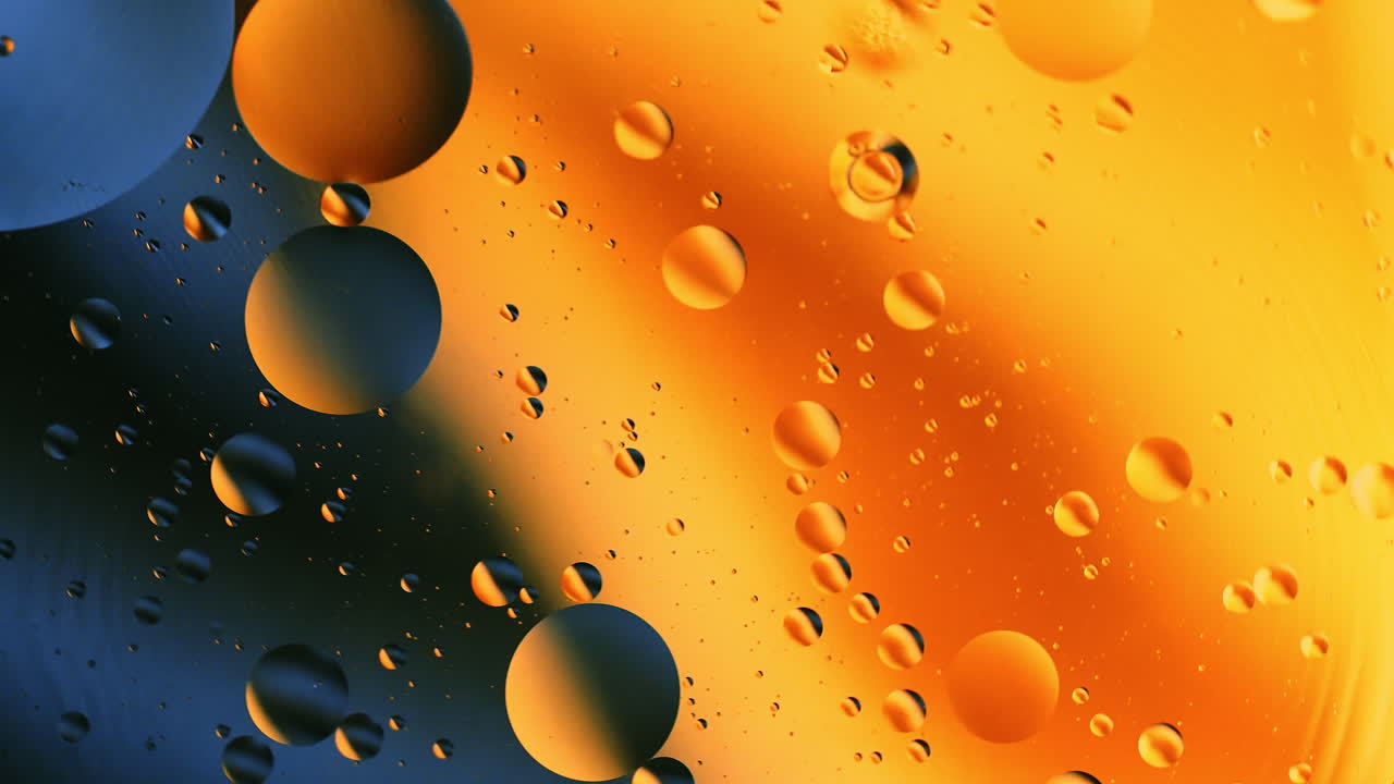 Primo piano ravvicinato di bolle d'olio in rotazione nell'acqua con sfondo astratto di miscelazione a gradiente di colore