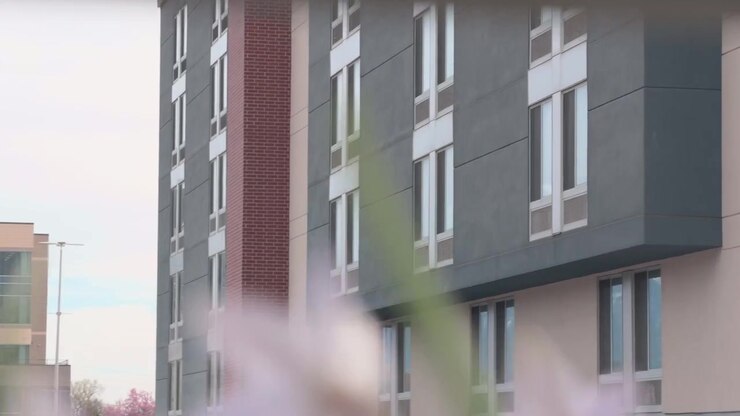 Lento movimento verso l'alto che rivela la facciata di un edificio con elementi sfocati e morbidi in primo piano.