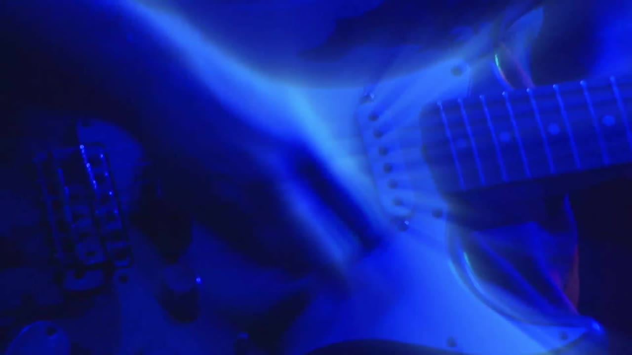 Playing electric guitar, blue light animation over musician's hands and instrument