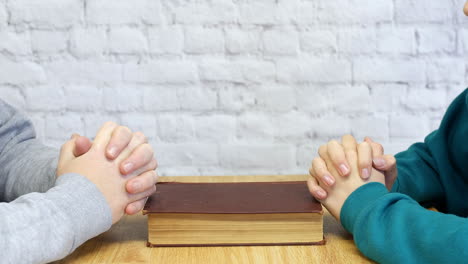 A-man-parying-with-a-female-wife-daughter-or-friend-with-a-bible-on-a-table