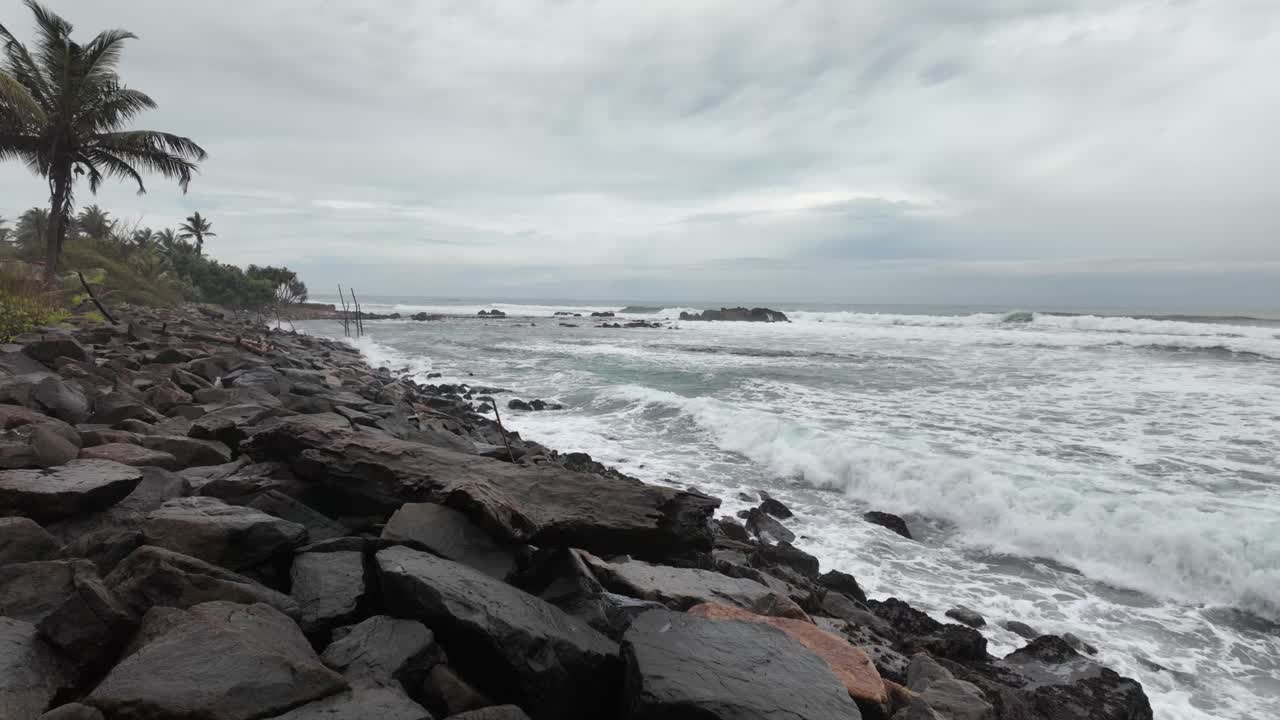 Stormy Indian Ocean coastline water waves rocky dramatic tropical paradise rainy season