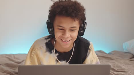 teenage boy with laptop in bed