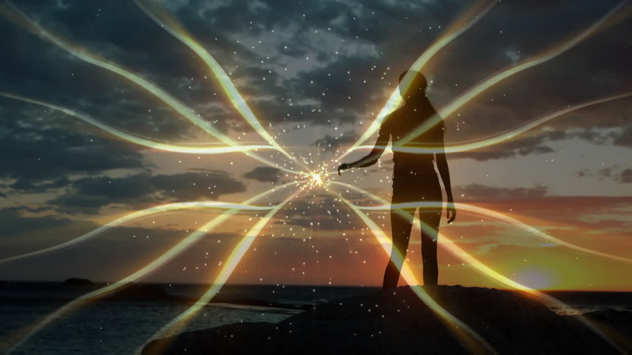 female silhouette standing on rocks at sunset, interacting with golden ribbon beams for tech design
