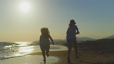 children running on the beach at sunset