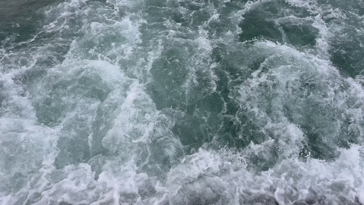 Vue hypnotisante de dessus au ralenti de puissantes vagues océaniques qui s'écrasent et se déchaînent. Belle mousse de mer blanche dynamique et éclaboussures d'eau créant un fond abstrait de nature marine.