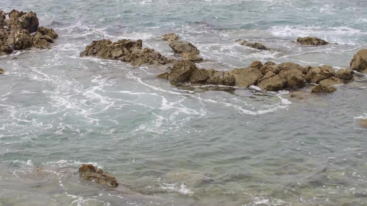 Poza de Marea Rocosa a lo Largo de la Costa del Pacífico con Potentes Olas del Océano Rompiendo Bajo un Cielo Nublado y Sombrío