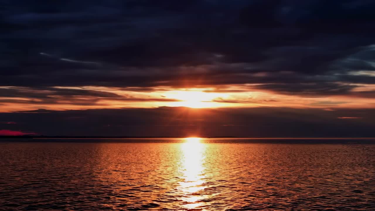 Ein ruhiger Sonnenuntergang über dem Meer mit dramatischen Wolken, aus einem niedrigen Winkel aufgenommen