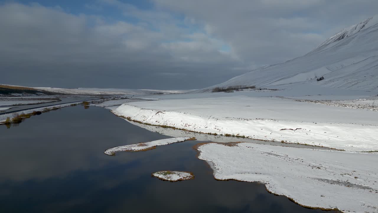 спокойная река на фоне заснеженного горного пейзажа в прекрасной исландии, аэрофотосъемка
