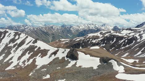 Luftpanoramablick-Auf-Die-Atemberaubende-Bergkette,-Die-Teilweise-Mit-Schnee-Bedeckt-Ist-1