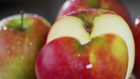 una cámara pasa por encima de las manzanas húmedas, una de ellas se corta por la mitad con un cuchillo