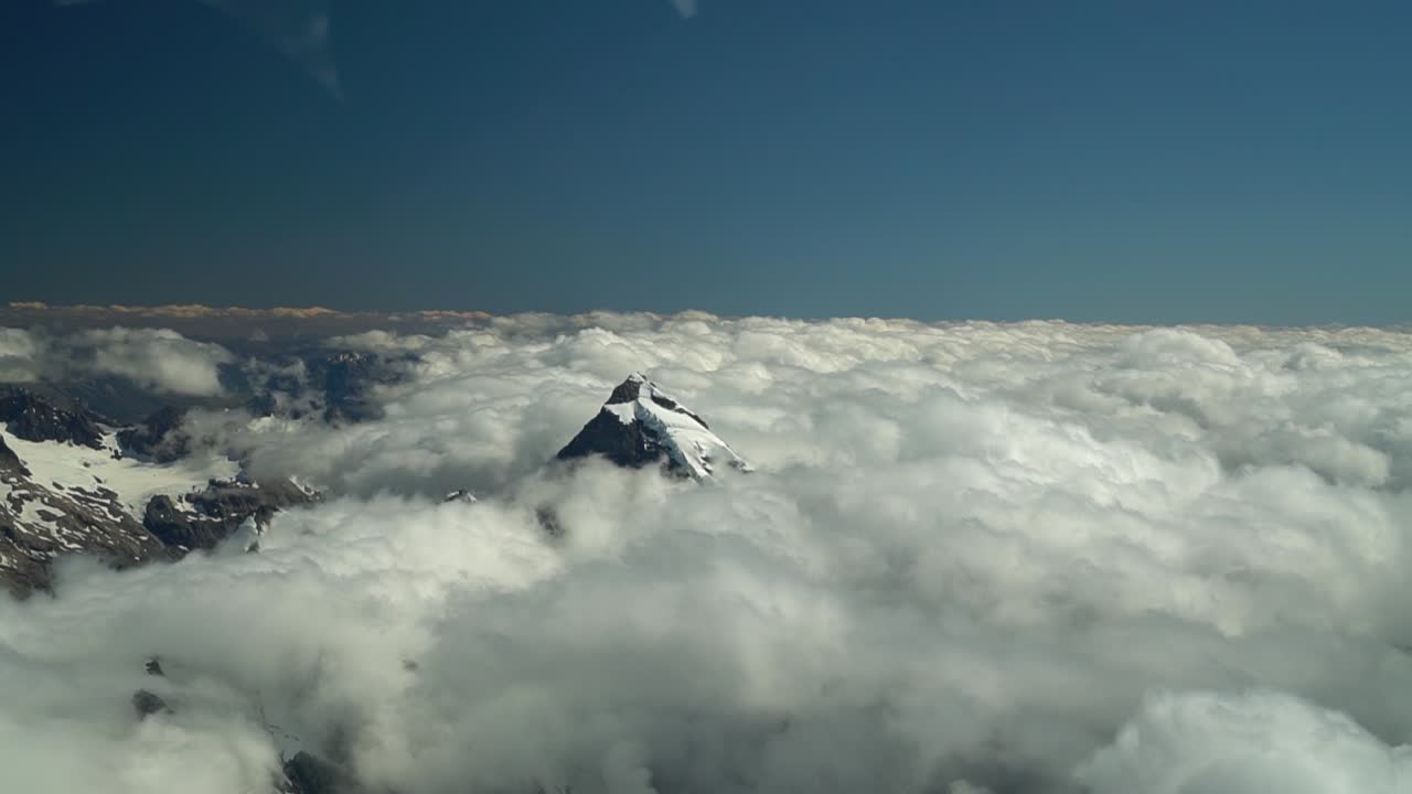 cámara lenta - monte tasman, alpes del sur, nueva zelanda - cumbre nevada en las nubes desde un vuelo panorámico en avión