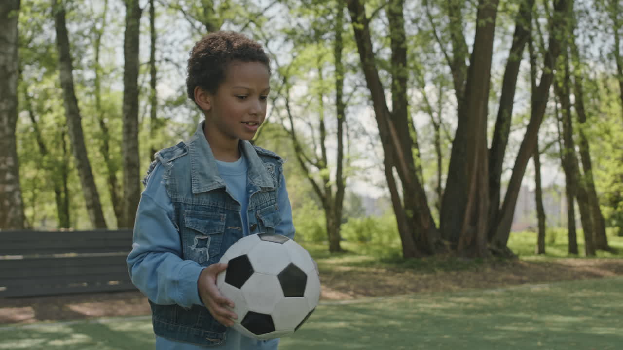 Little Boy Going to Kick Soccer Ball in Park