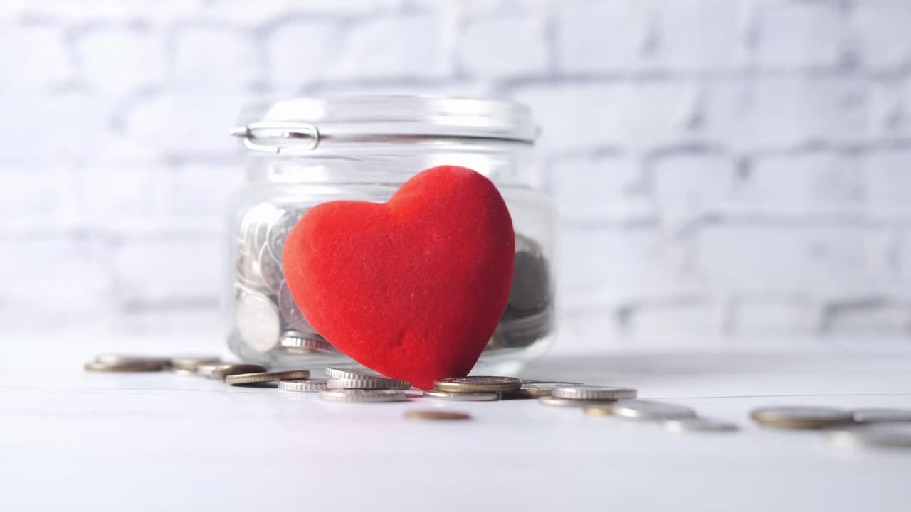 동전으로 가득 찬 은 심장 모양의 기증 항아리