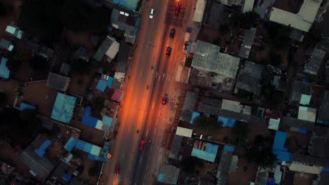 Filmische-4k-Luftdrohnenaufnahme-Von-Oben-Nach-Unten-Vom-Straßenverkehr-Bei-Nacht-Mit-Autos,-Die-Während-Der-Hauptverkehrszeit-In-Der-Afrikanischen-Stadt-Fahren---Lomé,-Afrika