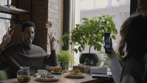 Friends taking pictures in a cafe