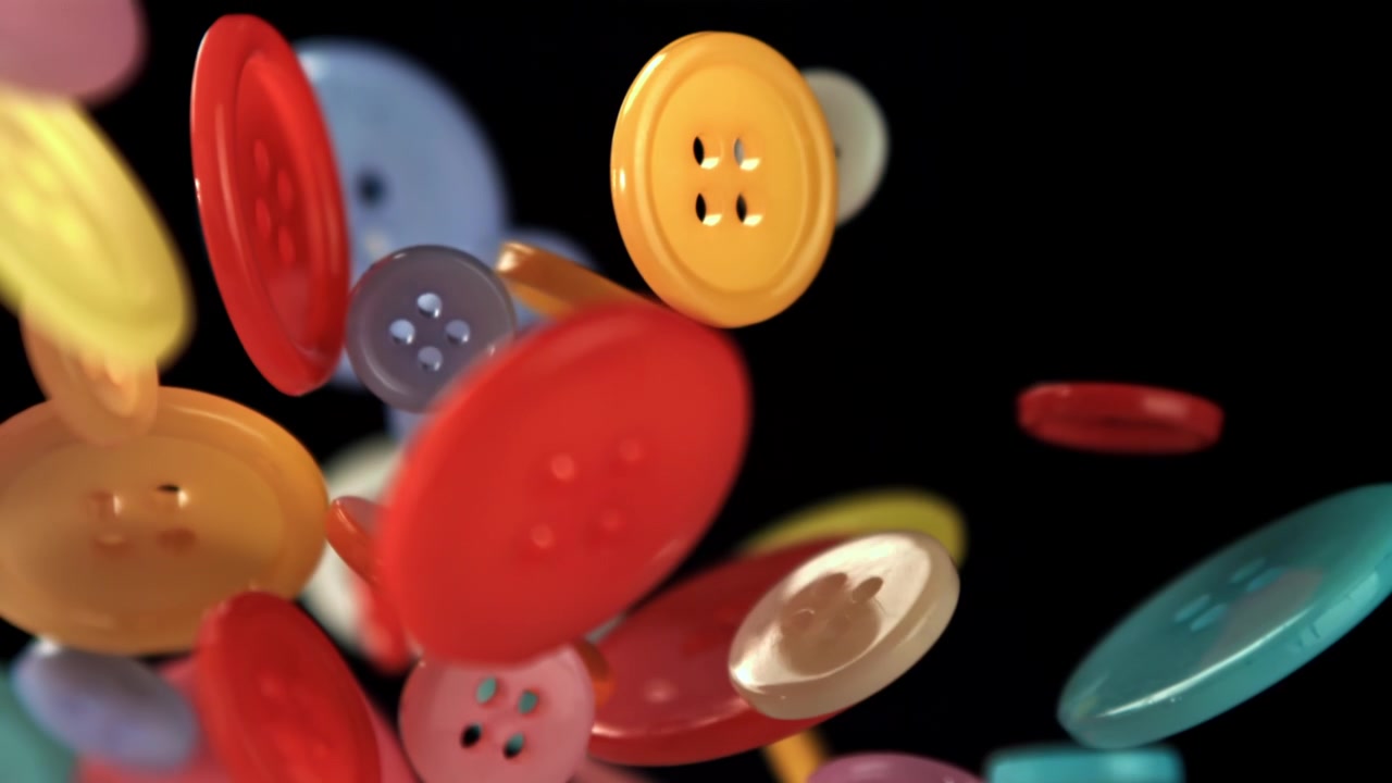Diverse fargerike knapper som faller i sakte film
